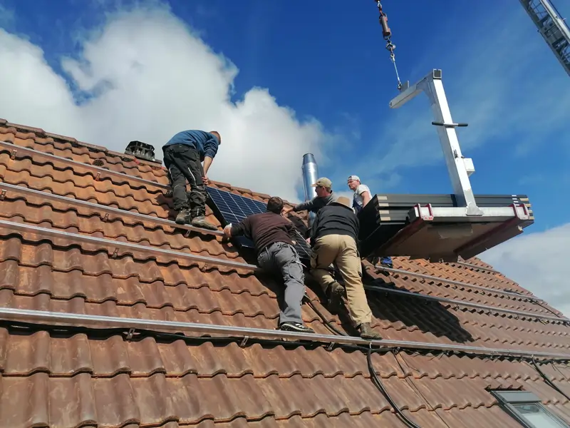 Die Solarmodule werden während der Installation der PV Anlage verlegt.