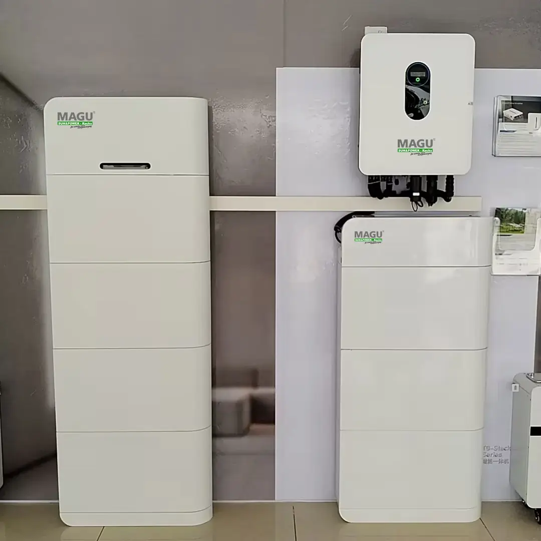 Zwei MAGU Energy Batteriespeicher neben einem Wechselrichter für Energieunabhängigkeit und Notstromversorgung in einem Ausstellungsraum.